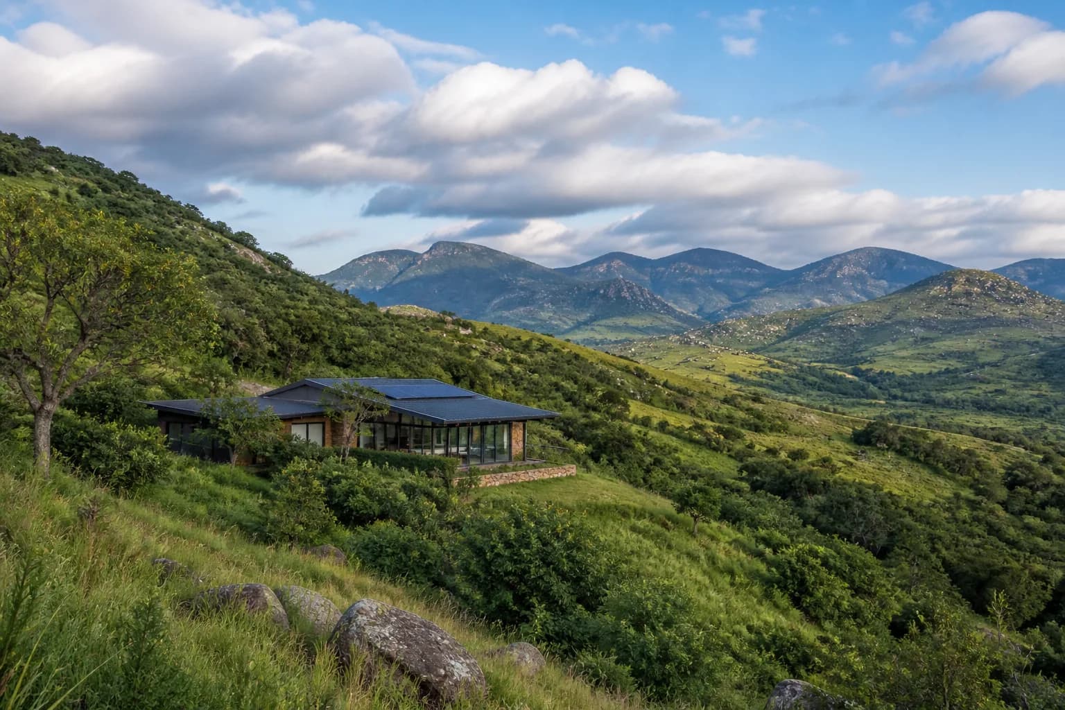 Home nestled in green Eswatini hills under an open sky